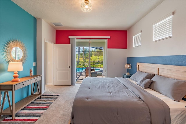 carpeted bedroom with access to outside and a textured ceiling