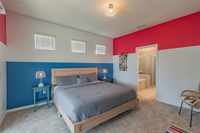 bedroom with connected bathroom, a textured ceiling, and carpet floors