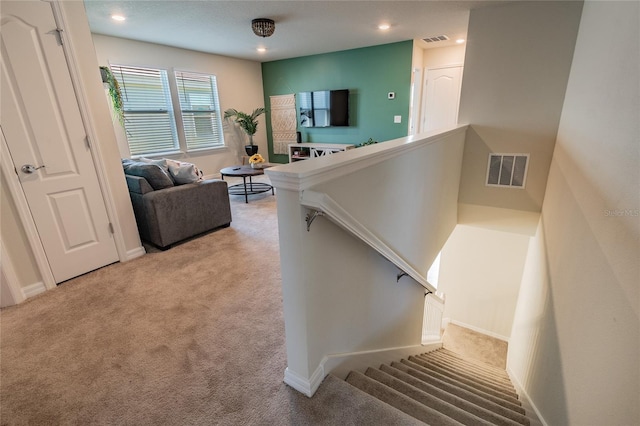 staircase featuring carpet