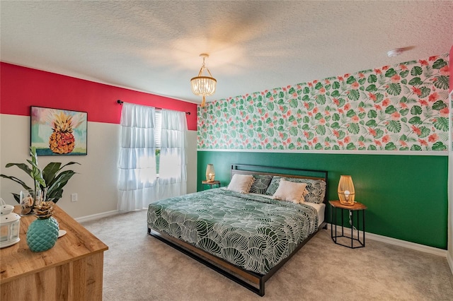 bedroom featuring an inviting chandelier, a textured ceiling, and carpet floors