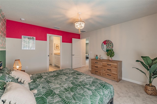 carpeted bedroom with ensuite bath, a textured ceiling, and an inviting chandelier