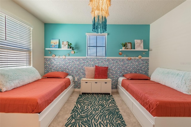 carpeted bedroom with a textured ceiling and a notable chandelier