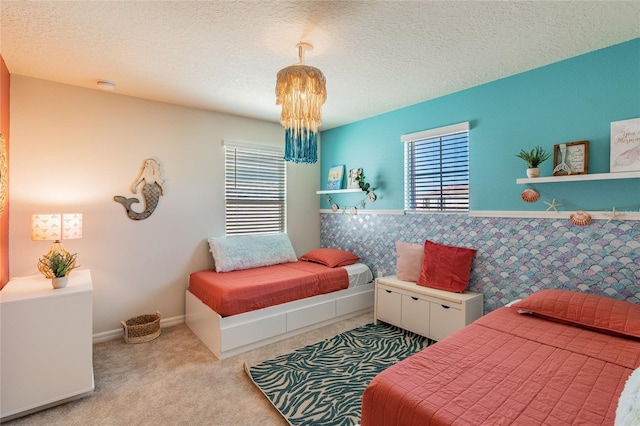 carpeted bedroom featuring a textured ceiling and an inviting chandelier