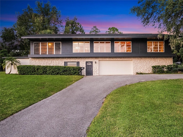 view of front of house with a garage and a lawn