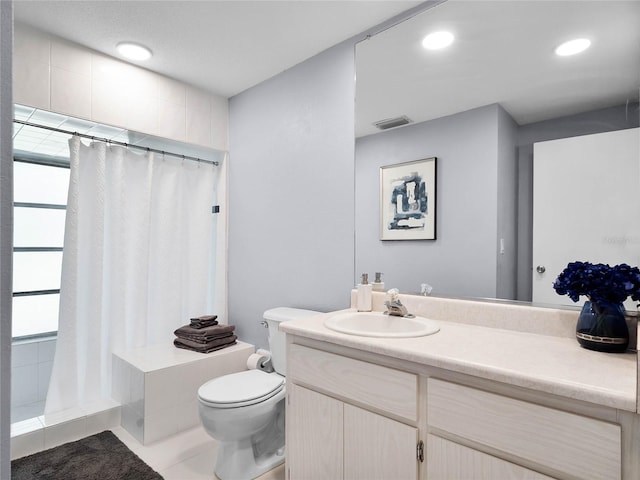 bathroom featuring toilet, vanity, a shower with shower curtain, and tile patterned floors