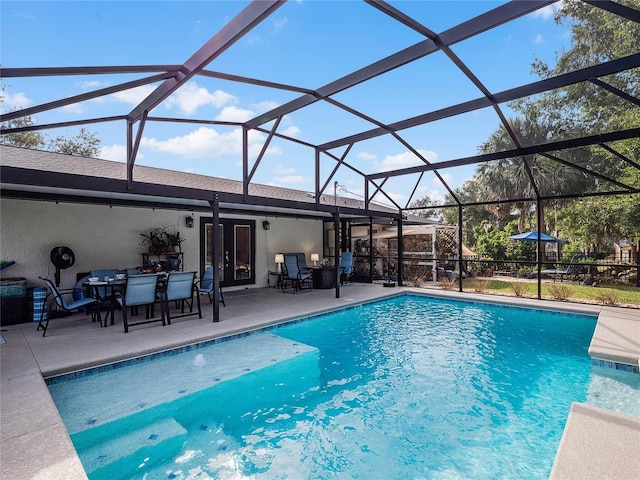 view of pool with glass enclosure and a patio