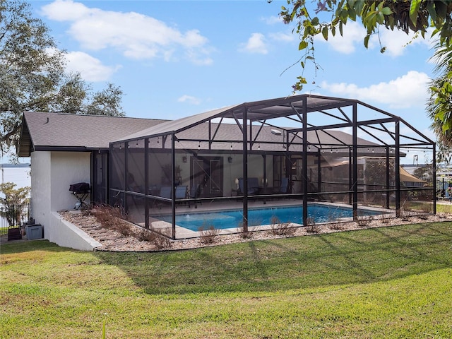 view of swimming pool with a lawn and a lanai