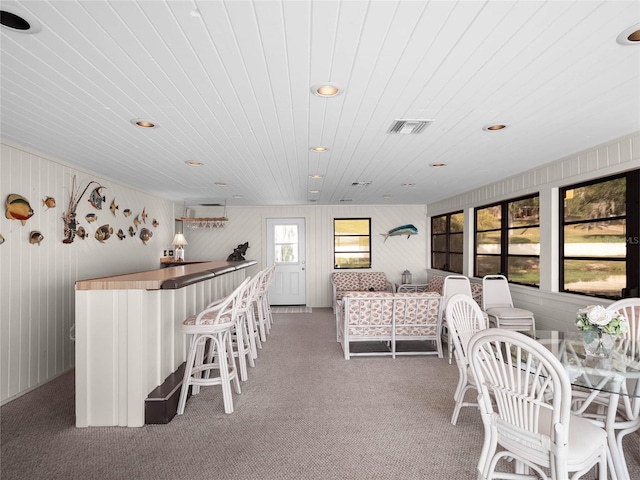 interior space featuring bar, wood ceiling, and carpet floors