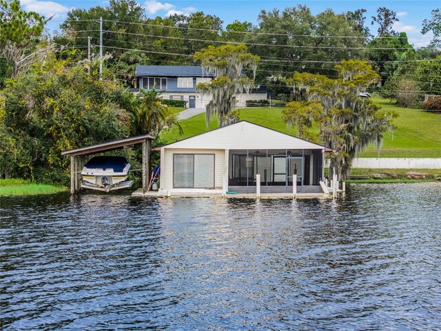 rear view of property with a water view and a lawn