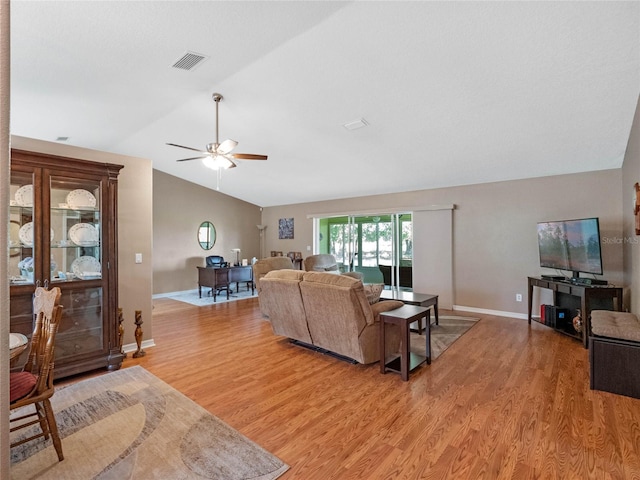 living room featuring ceiling fan, light wood-type flooring, and lofted ceiling