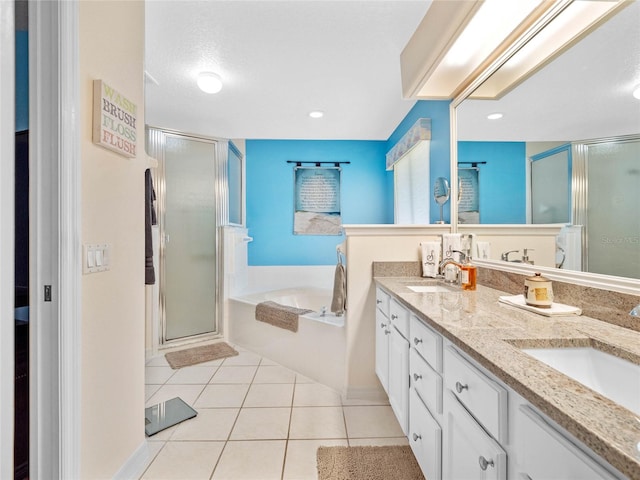 bathroom featuring tile patterned flooring, vanity, a textured ceiling, and plus walk in shower