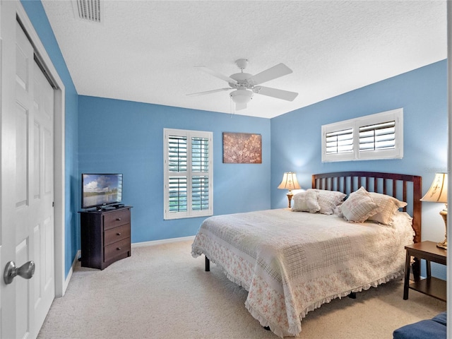 carpeted bedroom featuring a closet, a textured ceiling, and ceiling fan