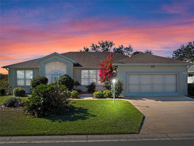 ranch-style house with a yard and a garage