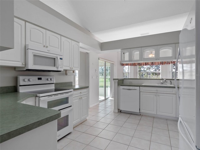 kitchen with white cabinets, light tile patterned flooring, white appliances, and sink