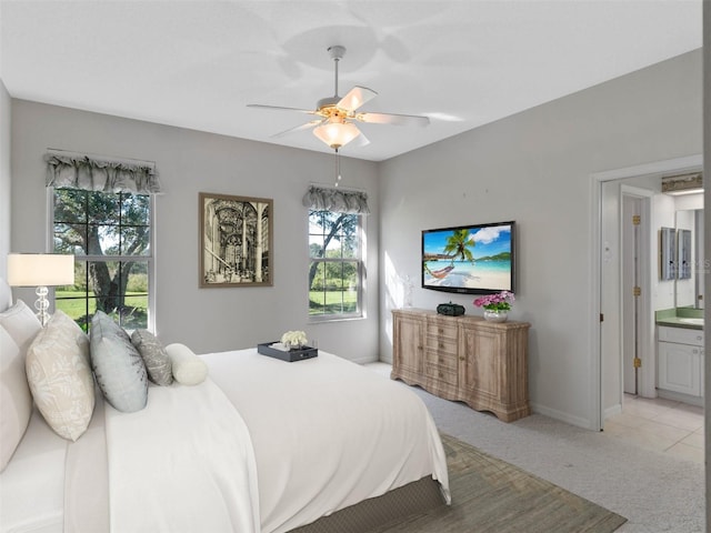 carpeted bedroom with ceiling fan and ensuite bath