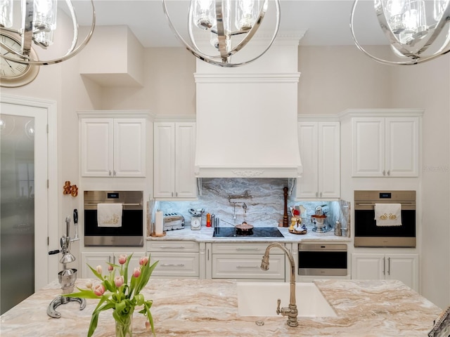 kitchen featuring white cabinetry, light stone countertops, stainless steel appliances, backsplash, and custom exhaust hood