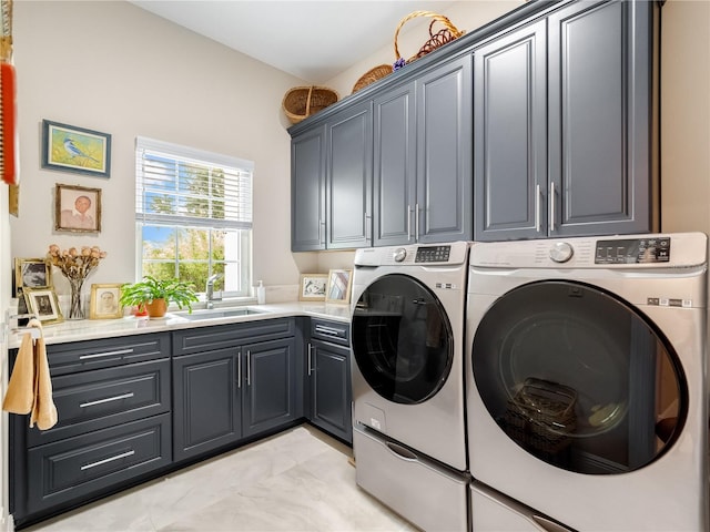 laundry area with cabinets, washing machine and dryer, and sink