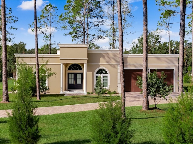 view of front of home featuring french doors, a garage, and a front lawn