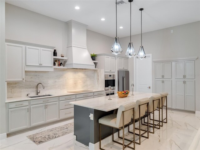 kitchen featuring a center island, premium range hood, high end refrigerator, sink, and a breakfast bar area