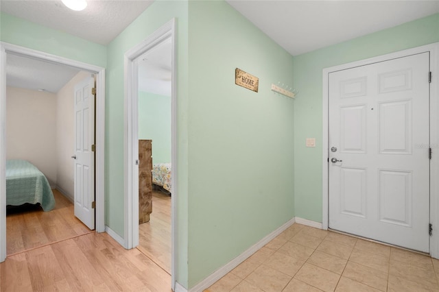 foyer entrance featuring baseboards and light tile patterned floors