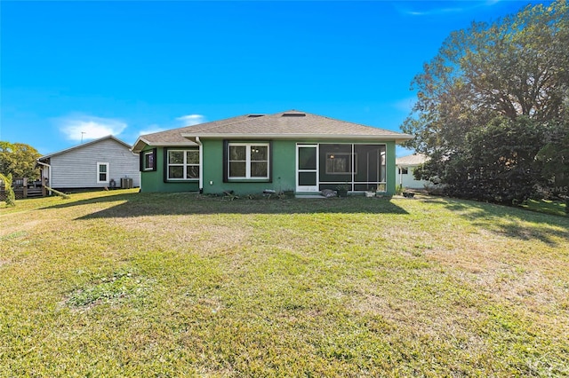 back of property featuring cooling unit, a sunroom, a yard, and stucco siding