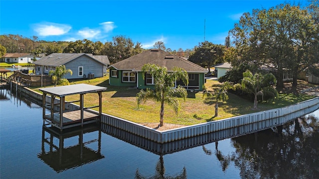 back of house with a lawn, a water view, and a residential view