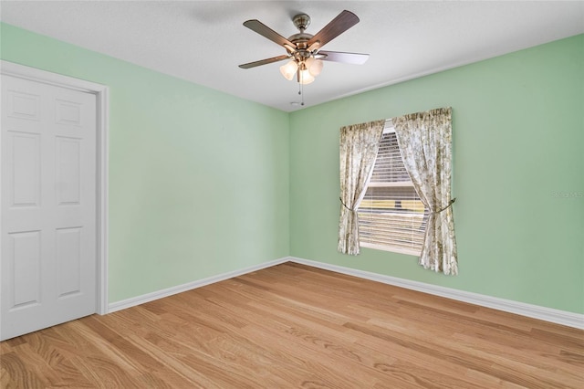 unfurnished room with light wood-style floors, ceiling fan, and baseboards