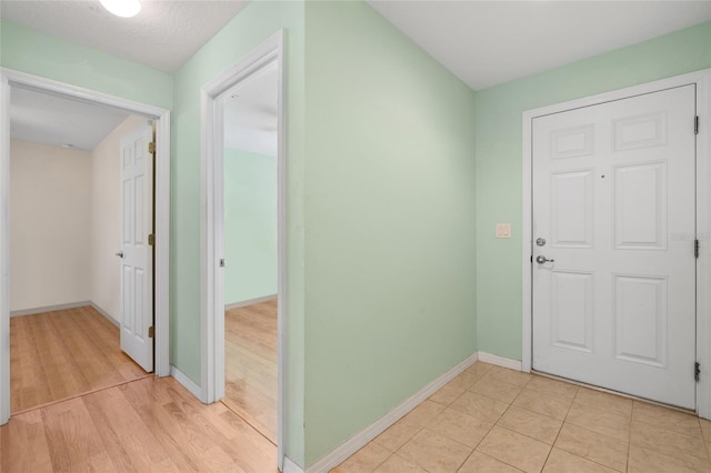 foyer with light wood finished floors and baseboards