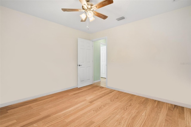 empty room featuring light wood finished floors, baseboards, visible vents, and ceiling fan