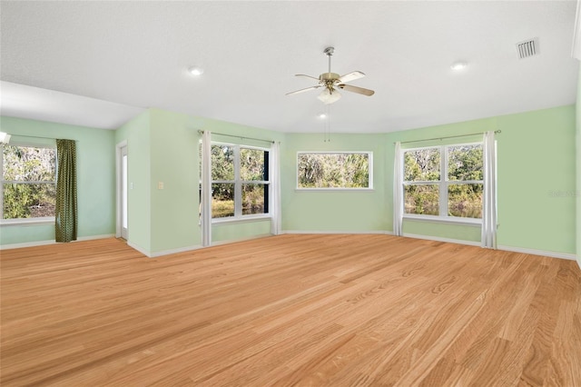 unfurnished living room featuring light wood-style floors, visible vents, ceiling fan, and baseboards