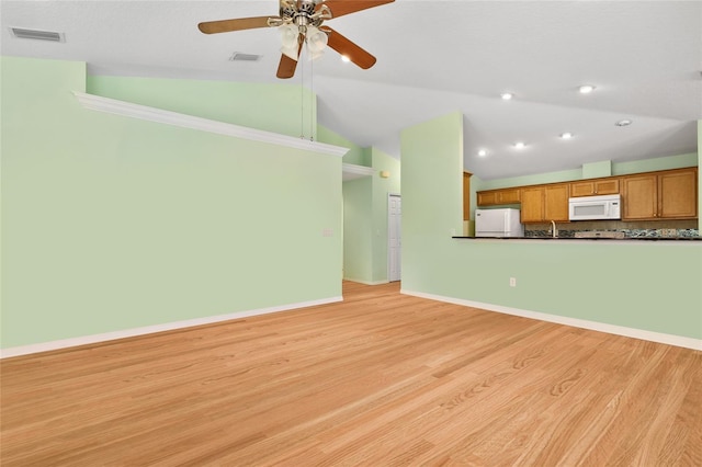 unfurnished living room with baseboards, visible vents, vaulted ceiling, and light wood finished floors