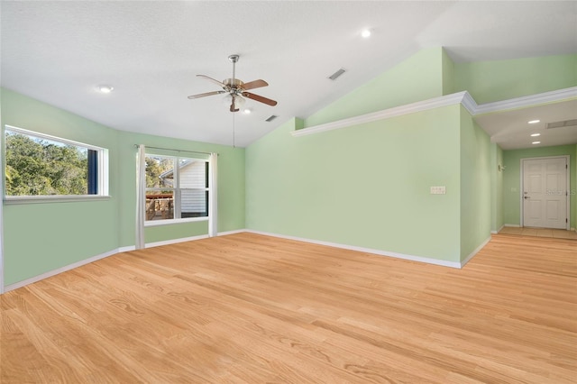 spare room featuring light wood finished floors, visible vents, a ceiling fan, high vaulted ceiling, and baseboards