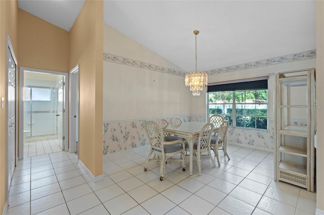 tiled dining room featuring a chandelier and lofted ceiling