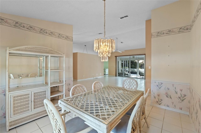 tiled dining area with ceiling fan with notable chandelier, lofted ceiling, and a textured ceiling