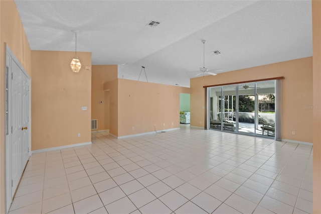 empty room with a textured ceiling, high vaulted ceiling, light tile patterned flooring, and ceiling fan with notable chandelier