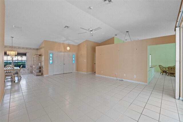 interior space featuring ceiling fan with notable chandelier, high vaulted ceiling, and light tile patterned flooring