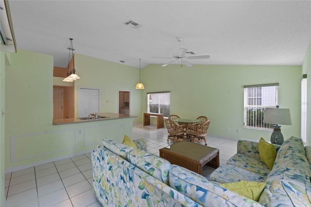 tiled living room featuring ceiling fan, sink, and lofted ceiling