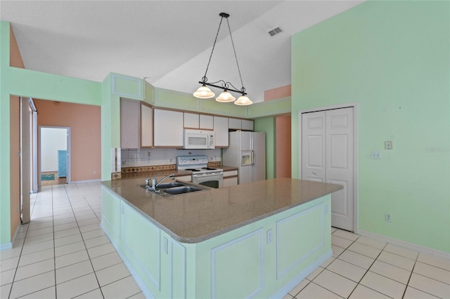 kitchen featuring sink, white appliances, kitchen peninsula, and light tile patterned floors