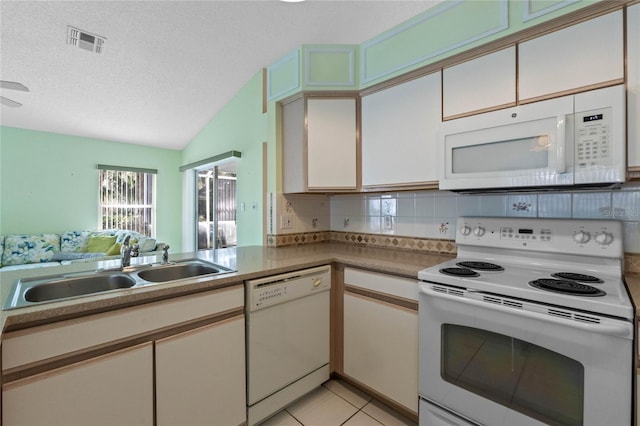 kitchen featuring sink, backsplash, a textured ceiling, white appliances, and light tile patterned floors