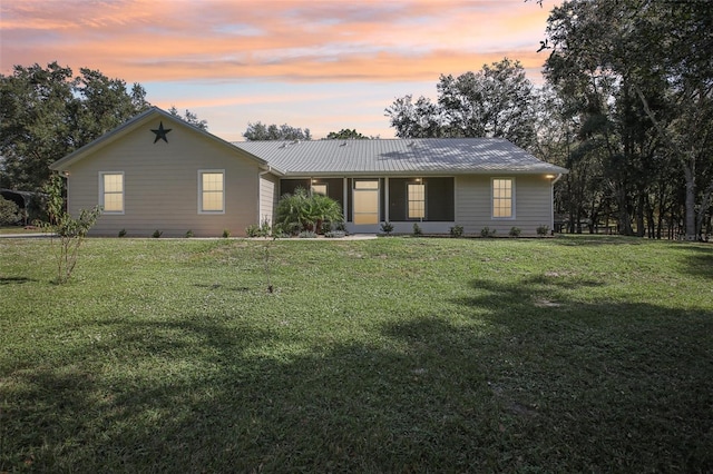 single story home featuring a lawn