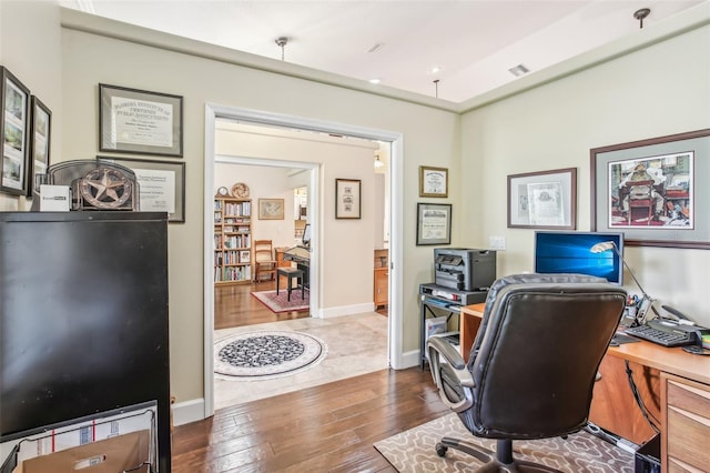 home office with dark hardwood / wood-style floors