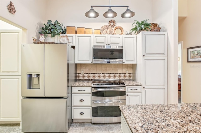 kitchen featuring appliances with stainless steel finishes, white cabinets, decorative backsplash, hanging light fixtures, and light stone counters