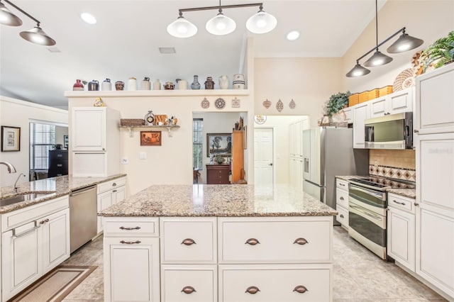 kitchen featuring sink, appliances with stainless steel finishes, backsplash, a kitchen island, and decorative light fixtures