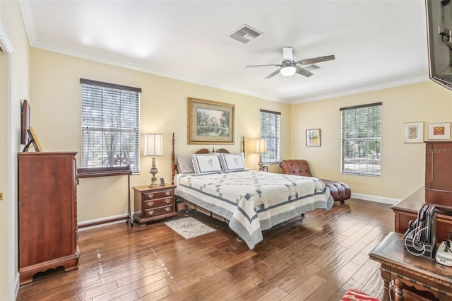 bedroom with dark hardwood / wood-style flooring, ornamental molding, and ceiling fan