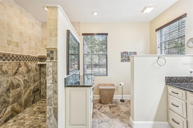 bathroom with vanity and a tile shower