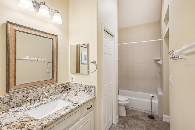 full bathroom featuring vanity, tiled shower / bath, and toilet