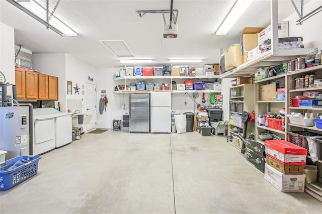 garage with a garage door opener, electric water heater, washing machine and clothes dryer, and stainless steel refrigerator