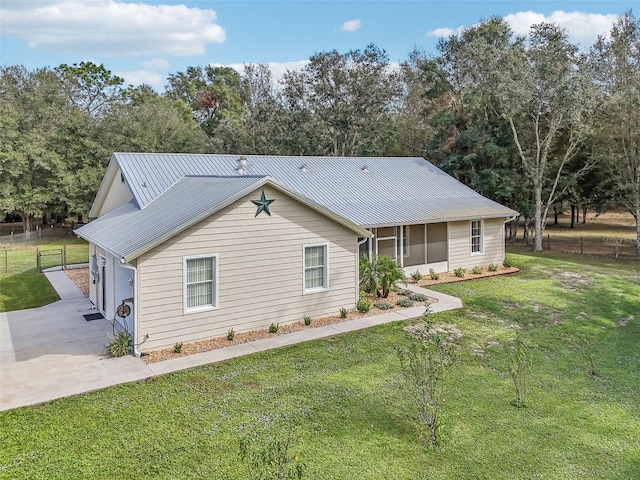 view of front facade featuring a garage, a sunroom, and a front yard