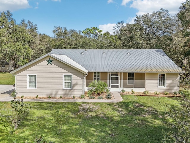 back of house featuring metal roof and a yard