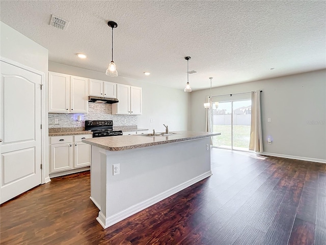 kitchen featuring black range oven, dark hardwood / wood-style flooring, white cabinets, and a center island with sink